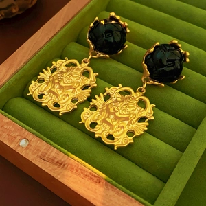 Vintage gold-tone lion head earrings with black stone in green velvet jewelry box