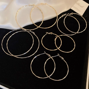 Five-piece set of textured hoop earrings in gold and silver finish on black velvet