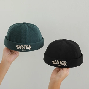 Dettaglio del ricamo Boston su cappelli miki in velluto a coste verde e nero