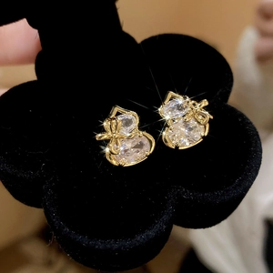 Macro shot of gold-plated hulu stud earrings with cubic zirconia and bow detail