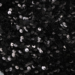 Détail macro de paillettes noires scintillantes sur velours pour mini robe de soirée