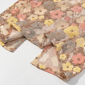 Vue détaillée de la broderie florale à paillettes roses et jaunes sur une robe de bal