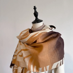 Detailed drape of beige and brown cashmere-feel scarf with geometric abstract print