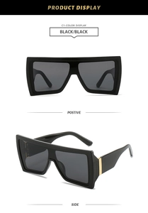 Detail view of black oversized square sunglasses with gold metal decorative temple accents