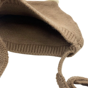 Detailed macro view of the brown knit baby hat showing interior texture and ribbed edges