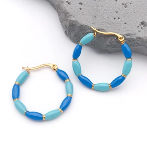 Detail of gold bamboo-shaped hoop earrings with blue and turquoise enamel inlays