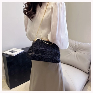 Detail of 3D rose petal texture on black evening bag with crystal-encrusted gold clasp