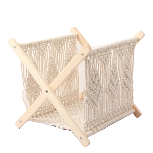 Close-up of bohemian hand-woven cotton rope magazine rack with a solid wood frame
