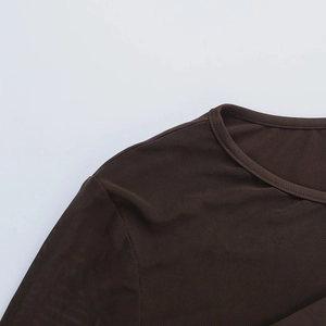 Dettaglio di cuciture in rete velata e bordi in maglia sulla scollatura dell'abito marrone
