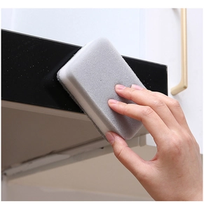 Detail of grey double-sided scouring pad cleaning a dark surface with hand demonstration