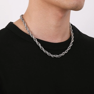 Detailed view of silver twist rope chain necklace worn by male model on neck