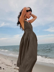 Détail du décolleté en V d'une robe longue en coton marron avec taille plissée et dos nu