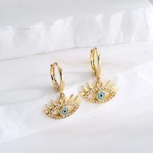 18K gold-plated evil eye hoop earrings with blue cubic zirconia on a white stone background