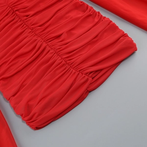 Gros plan détaillé sur la texture du tissu plissé rouge et le design froncé de la robe