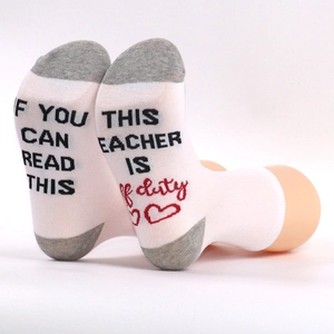 Detail of cotton socks with 'IF YOU CAN READ THIS TEACHER IS OFF DUTY' text on the sole