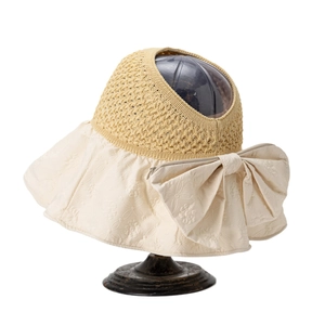Women's wide brim sun visor with floral texture and large bow on a white background
