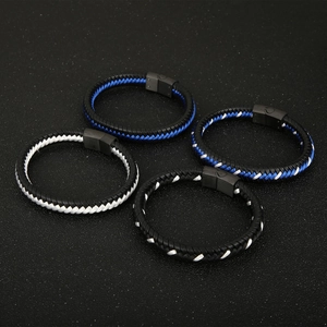 Detail of woven cotton cord bracelets with black magnetic clasps on textured background