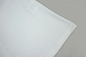 Gros plan détaillé de l'ourlet à double surpiqûre et de la texture de cette robe blanche