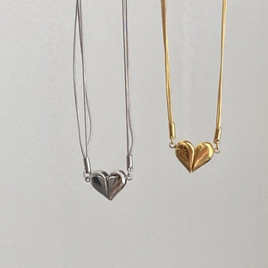 Detail of heart pendants in gold and silver finishes on delicate snake chains