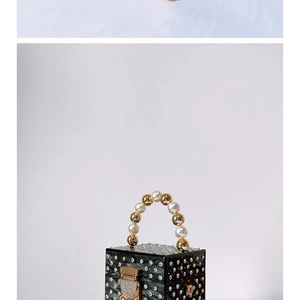 Detail of black acrylic evening bag featuring silver rhinestones and pearl beaded handle