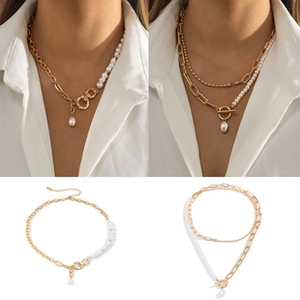 Detail view of layered gold chain necklaces with pearls and T-bar toggle clasp closures
