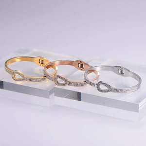 Detailed view of hinged Christmas bangles in gold, rose gold, and silver with zircon stones