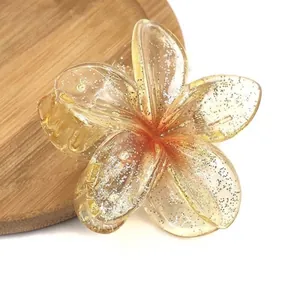 Detailed macro view of an amber resin flower hair claw clip with shiny silver glitter