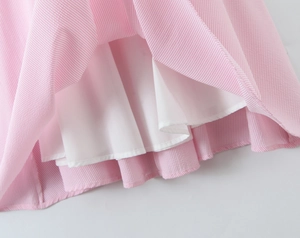 Detail of pink and white striped dress hem showing delicate fabric texture and inner lining