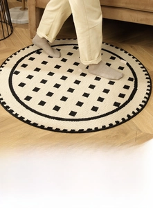 Close-up of soft loop pile circular rug with geometric grid pattern and woven edges