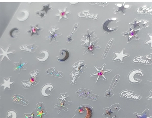 Macro shot of 5D silver star and moon nail stickers with 3D embossed texture and rhinestones