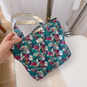 Close-up of vintage floral canvas tote bag with white webbing handles and a simple text label