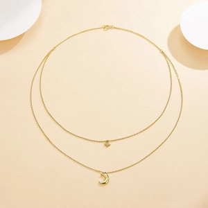 Close-up of gold double-layer necklace with diamond star and crescent moon pendants