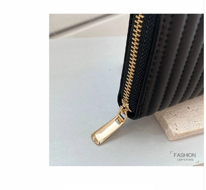 Close-up of black quilted PU leather wallet featuring a premium gold-tone zipper detail