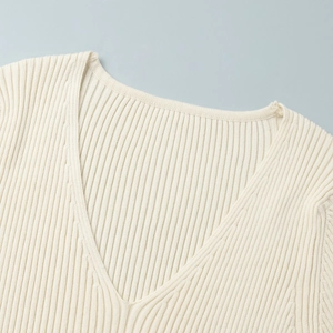 Macro view of V-neckline on off-white rib-knit dress with vertical texture details