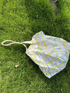 Detailed view of floral pattern tote bag on grass, showcasing rural french cotton style