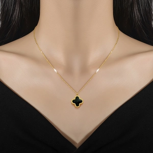 Minimalist gold titanium steel necklace with a double-sided black clover pendant on a model