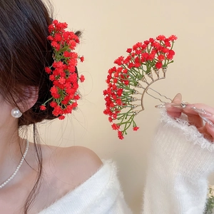 Close-up of red flower hair pin featuring a golden base and vibrant floral clusters