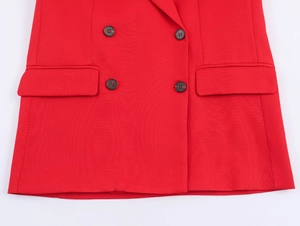 Detail of red double-breasted blazer showing twill fabric texture and black buttons