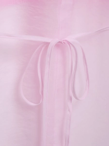 Dettaglio del fiocco in organza rosa in vita di questo elegante abito a camicia da donna