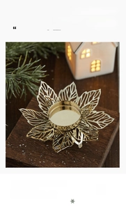 Détail d'un bougeoir flocon de neige doré avec feuilles évidées sur socle en bois
