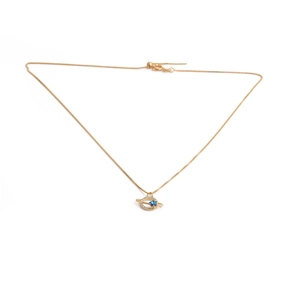 Detailed close-up of a golden planet necklace featuring a blue stone and crystal ring