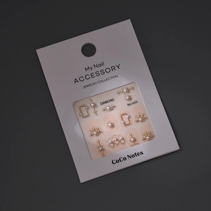 Detailed macro view of DIY pearl nail art charms with golden jewelry frames for manicure