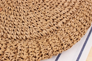 Macro shot of circular paper straw woven bag showing intricate crochet texture detail