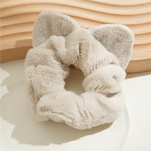 Close-up of beige plush scrunchie with cute cat ears made of soft faux fur fabric