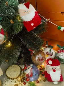 Detailed view of plush Christmas socks with Santa Claus pattern in festive gift packaging