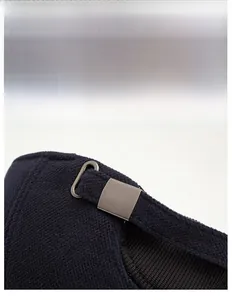 Detail of adjustable metal buckle and textured fabric on warm navy winter cap for men