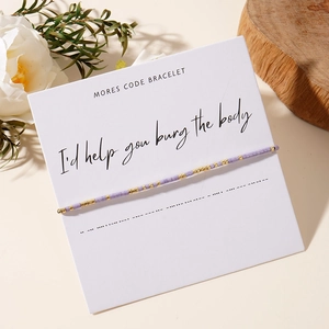 Morse code beaded bracelet with purple and gold cylinders on creative gift card