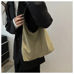 Model wearing a khaki matte faux suede shoulder bag with a black blazer for a stylish look