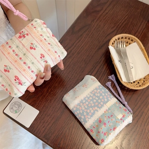 Close-up of floral fabric zipper pouches with colorful patterns and woven rope loops