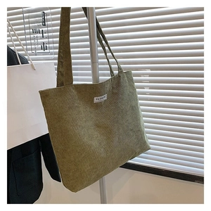 Detail of vintage green corduroy tote bag showing ribbed texture and Fashion label